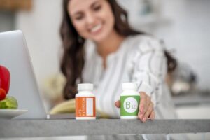 A young woman with a bottle of vitamin B12