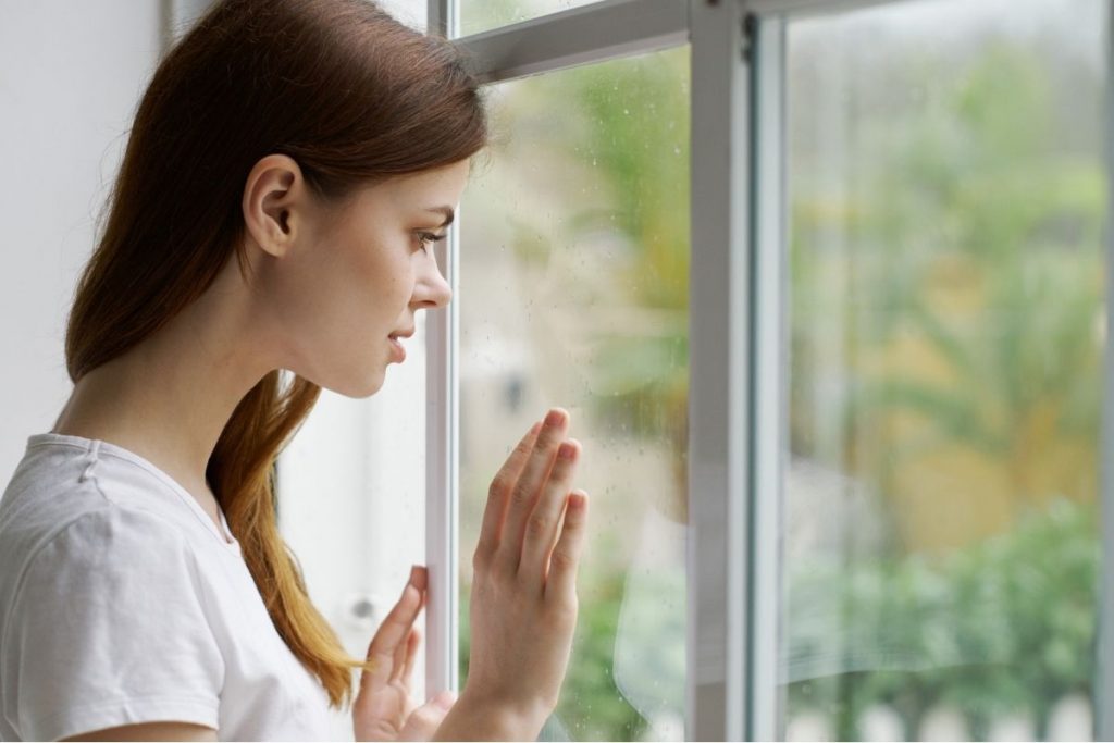 Woman looking out the window - photo by SHOTPRIME from Canva