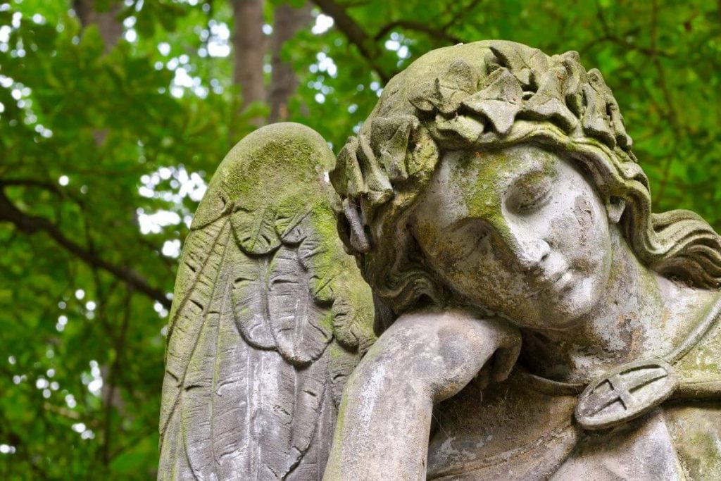 A beautiful statue of an angel thinking in the forest