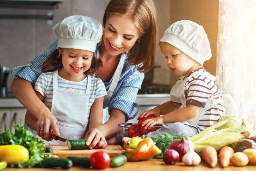 Mother and daughters preparing vegetables - photo by JenkoAtaman AdobeStock