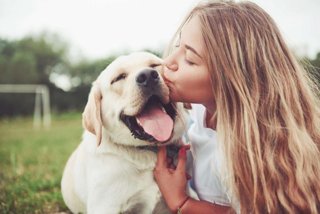 Are You Neglecting Your Dog? 2 Young woman kissing her labrador - standret iStock